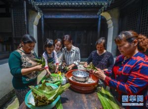 图为当日，村民们在范家老宅内包粽子。