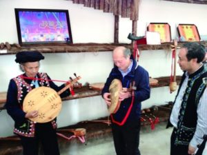 中国交响乐团团长关峡向老艺人学习弹奏哈尼族乐器